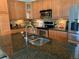 A kitchen featuring granite countertops, stainless steel appliances, and wood cabinets with tile backsplash at 10634 Ashfield St, Highlands Ranch, CO 80126
