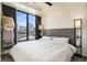 Bright bedroom featuring a bed with white linens and stunning city views from the large window at 1750 Wewatta St # 728, Denver, CO 80202