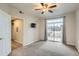 Bright bedroom with a sliding glass door, ceiling fan, and mounted TV at 7440 S Blackhawk St # 4-104, Englewood, CO 80112