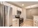 Well-lit kitchen with modern stainless steel appliances, white cabinets, and dining area at 7440 S Blackhawk St # 4-104, Englewood, CO 80112