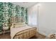 Inviting bedroom featuring wallpaper, a rattan bed frame, and sheer curtains at 1711 Boulder St, Denver, CO 80211