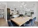 Open dining room with modern lighting, seating for eight, and a view into the kitchen and living area at 1711 Boulder St, Denver, CO 80211