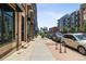 Street view showcasing a sidewalk lined with brick buildings and a view of the city skyline at 1711 Boulder St, Denver, CO 80211