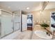 Bathroom featuring double sinks, tub shower with sliding glass doors, and view into bedroom at 1824 Morningview Ln, Castle Rock, CO 80109