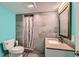 Modern bathroom featuring tiled shower, granite countertop, vanity, and a blue accent wall at 1824 Morningview Ln, Castle Rock, CO 80109