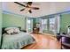 Bedroom with green walls, light wood floors, a ceiling fan and an abundance of natural light at 1824 Morningview Ln, Castle Rock, CO 80109