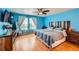 Bright bedroom with blue walls, wood floors, ceiling fan, and a unique wooden headboard at 1824 Morningview Ln, Castle Rock, CO 80109