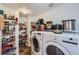 Well-stocked pantry with wire shelving and appliances and washer and dryer in the foreground at 1824 Morningview Ln, Castle Rock, CO 80109