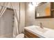 Stylish bathroom with a tiled shower featuring a unique curtain and a modern vanity with a framed mirror at 10956 Osprey Ct, Parker, CO 80134