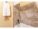 Close-up of the neutral-colored tile shower with bronze fixtures and a white shower-tub at 10956 Osprey Ct, Parker, CO 80134