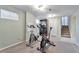 Carpeted exercise room with exercise bikes, white board, and basement stairs at 13742 W 67Th Pl, Arvada, CO 80004