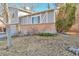 Multi-level home with a brick foundation, gray siding, and a well-maintained lawn at 13742 W 67Th Pl, Arvada, CO 80004