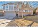 Charming home with a brick and siding facade, featuring a two-car garage and a well-manicured front yard at 13742 W 67Th Pl, Arvada, CO 80004