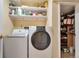 Well-organized laundry room featuring a white washer and dryer, shelving, and ample storage space at 13742 W 67Th Pl, Arvada, CO 80004