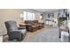 Comfortable living room with plush reclining sofa, large window, and neutral decor at 13742 W 67Th Pl, Arvada, CO 80004