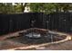 Backyard featuring a black wood fence and gravel fire pit with seating at 11384 Oakland Dr, Commerce City, CO 80640