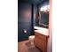 Stylish half-bathroom featuring blue walls, a modern vanity and ornate mirror at 11384 Oakland Dr, Commerce City, CO 80640