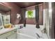 Bathroom featuring a soaking tub, modern vanity and a window for natural light at 11384 Oakland Dr, Commerce City, CO 80640