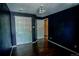 Bedroom featuring dark walls, hardwood floors, and closet at 11384 Oakland Dr, Commerce City, CO 80640