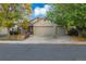 Charming two-story home with a brick facade, mature trees, and a spacious driveway at 11384 Oakland Dr, Commerce City, CO 80640