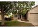 Charming brick home with a well-manicured front yard, mature shade tree, and attached garage at 11384 Oakland Dr, Commerce City, CO 80640