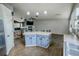 Open-concept kitchen with a center island, modern lighting, and stainless steel appliances at 11384 Oakland Dr, Commerce City, CO 80640