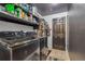 Well-appointed laundry room with black appliances, ample shelving and a modern aesthetic at 11384 Oakland Dr, Commerce City, CO 80640