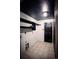Clean laundry area featuring tile floors, shiplap walls, and sleek black fixtures at 11384 Oakland Dr, Commerce City, CO 80640