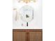 Elegant bathroom featuring a round mirror, modern sink, and woven wood vanity at 1543 S Ouray Cir # B, Aurora, CO 80017