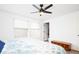 Well-lit bedroom featuring windows, a ceiling fan, and a cozy bed at 1543 S Ouray Cir # B, Aurora, CO 80017