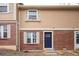 Inviting townhome exterior with brick accents, tan siding, and a blue front door, creating curb appeal at 1543 S Ouray Cir # B, Aurora, CO 80017