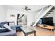 Cozy living room features a plush blue sectional, a glass coffee table, sliding doors to the backyard and a staircase at 1543 S Ouray Cir # B, Aurora, CO 80017