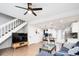 Open concept living room featuring a staircase, a kitchen, a plush blue sectional, and a television at 1543 S Ouray Cir # B, Aurora, CO 80017