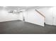 Large carpeted basement with white walls, lighting and access to an upper floor at 7603 W Coal Mine Pl, Littleton, CO 80128