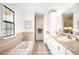 Spacious bathroom with double vanity, tiled countertops, shower, and soaking tub by a sunny window at 7603 W Coal Mine Pl, Littleton, CO 80128