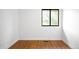 A clean, bright bedroom with wood floors, and a window overlooking a leafy green view at 7603 W Coal Mine Pl, Littleton, CO 80128