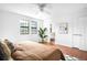 Bright bedroom featuring hardwood floors, white walls, ceiling fan, and an ensuite bath at 7603 W Coal Mine Pl, Littleton, CO 80128
