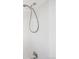 Close-up of shower with tiled walls, silver fixtures, and white trim at 7603 W Coal Mine Pl, Littleton, CO 80128