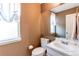 Cozy powder room featuring a large mirror, window, and a vanity at 4889 S Elkhart Ct, Aurora, CO 80015