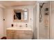 A bathroom featuring vanity with a sink, mirror, and a glass enclosed shower at 4889 S Elkhart Ct, Aurora, CO 80015