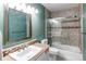 Well-lit bathroom featuring neutral tile, sliding shower doors and a framed mirror at 4889 S Elkhart Ct, Aurora, CO 80015