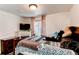 Comfortable bedroom showcases cozy bedding, a decorative fireplace, and natural light at 4889 S Elkhart Ct, Aurora, CO 80015