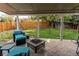 Inviting covered patio with comfortable seating, fire pit, and a view of the backyard at 4889 S Elkhart Ct, Aurora, CO 80015