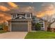 Inviting two-story home featuring a two-car garage, brick accents, and a lovely manicured front lawn at 4889 S Elkhart Ct, Aurora, CO 80015