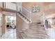 Elegant foyer with curved staircase, carpeted steps, and decorative floral art at 4889 S Elkhart Ct, Aurora, CO 80015