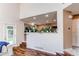 Open living area with pass-through to kitchen, filled with plants at 4889 S Elkhart Ct, Aurora, CO 80015