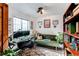 Charming home office features a desk, comfortable couch, and natural light from the window at 4889 S Elkhart Ct, Aurora, CO 80015