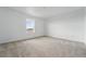 Bright bedroom with plush carpet, a large window offering plenty of natural light, and neutral paint at 2116 Chambers Rd, Brighton, CO 80601