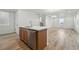 Modern kitchen with a center island and breakfast bar, stainless steel appliances, and wood floors at 2116 Chambers Rd, Brighton, CO 80601