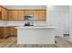 Modern kitchen featuring a large island, quartz countertops, stainless steel appliances, and wood cabinets at 2116 Chambers Rd, Brighton, CO 80601